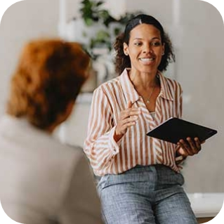 Businesswoman leading a meeting in a bright office, representing how employers can foster teamwork and support employee well-being.