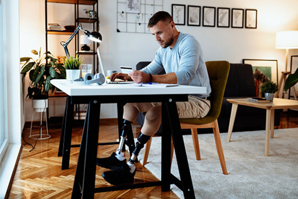 Life & Disability Insurance. A man sitting at a desk with a laptop, focused on his work.