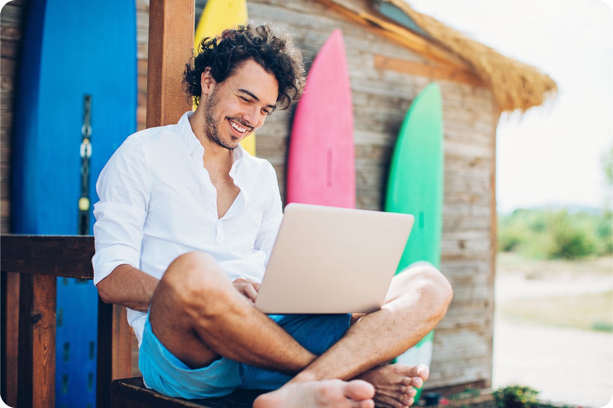 Young man working on laptop on a beach