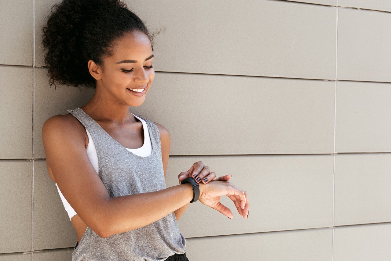 Fitness woman taking a break, checking activity tracker