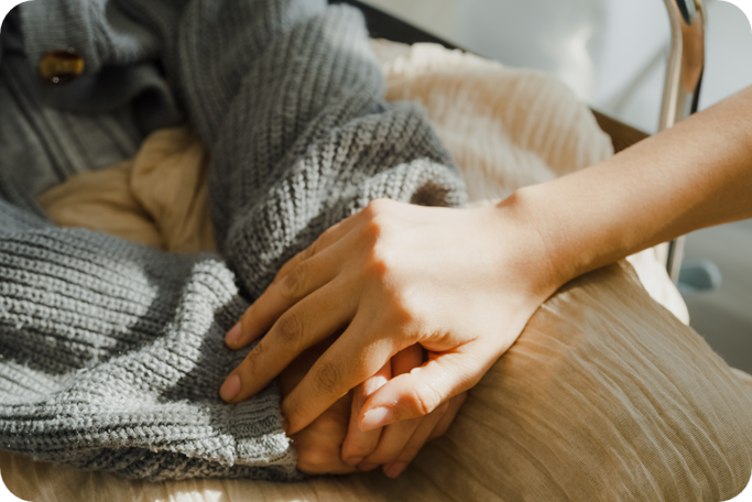 Two people holding hands, comforting each other