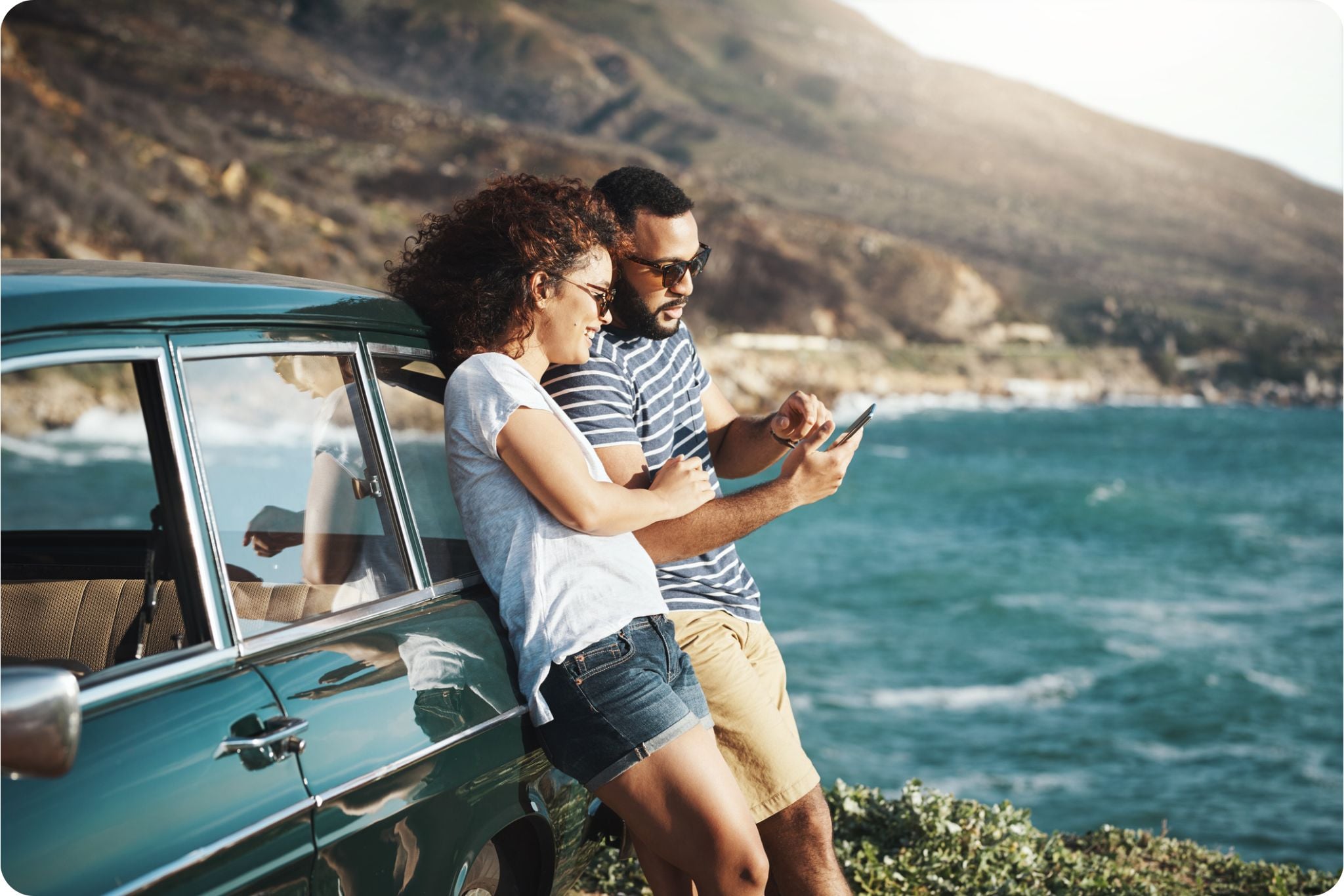a young couple using a mobile phone on a road trip