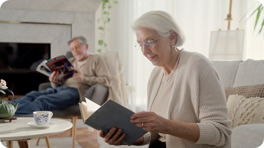 Senior woman reading book in living room