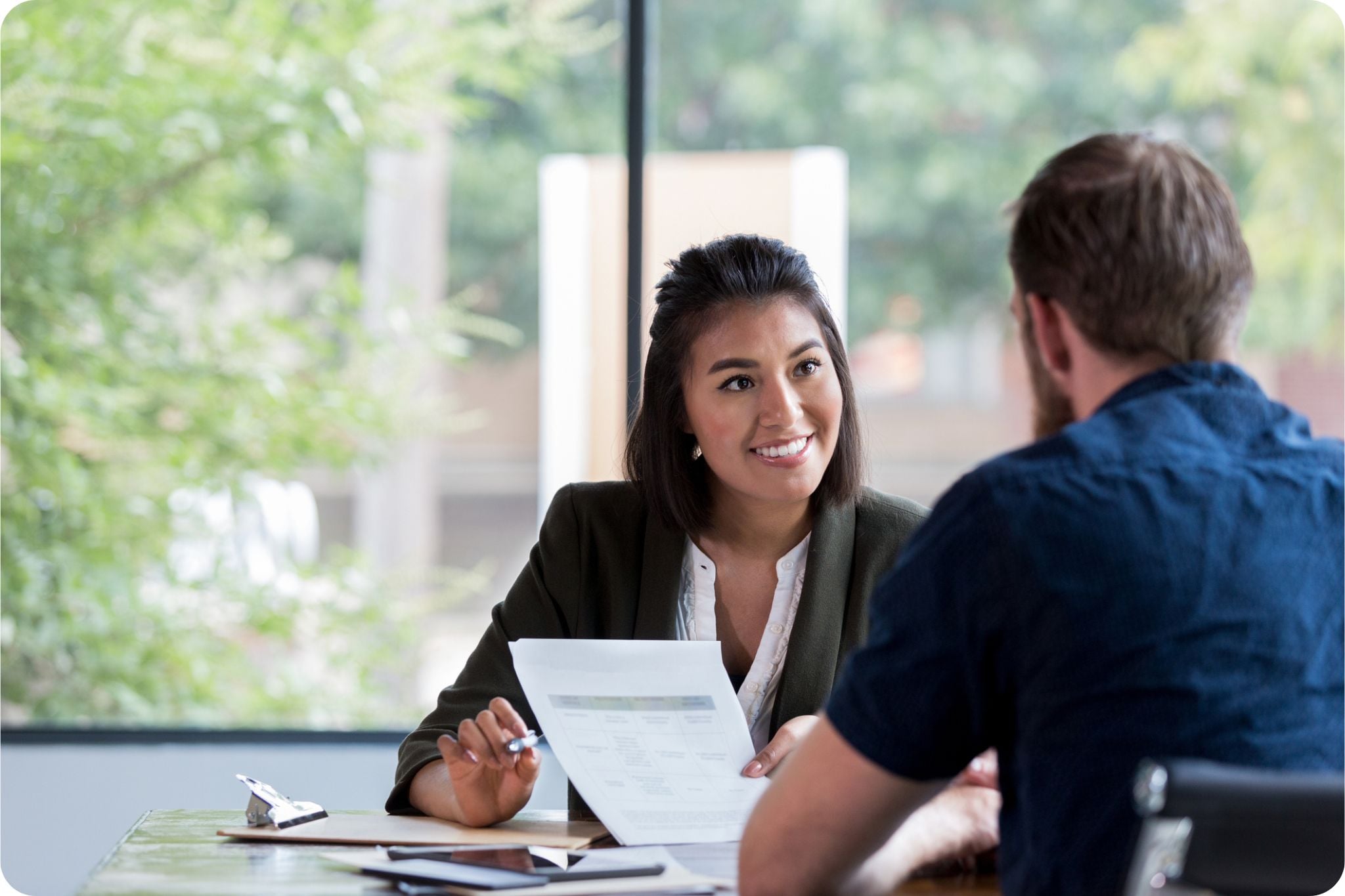 Advisor discussing a document with a client across a desk