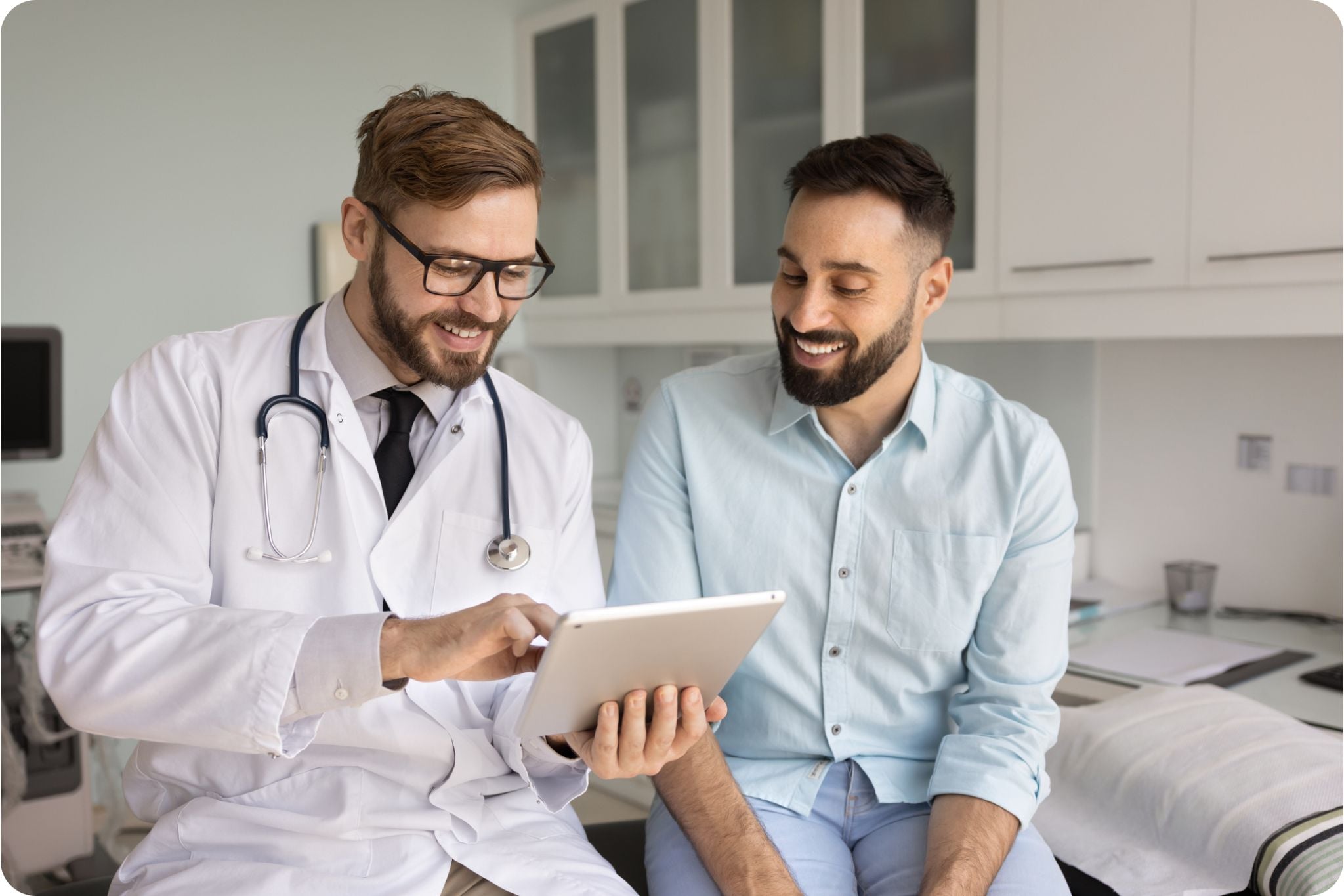 Doctor and male patient reviewing digital medical test results on a screen during consultation