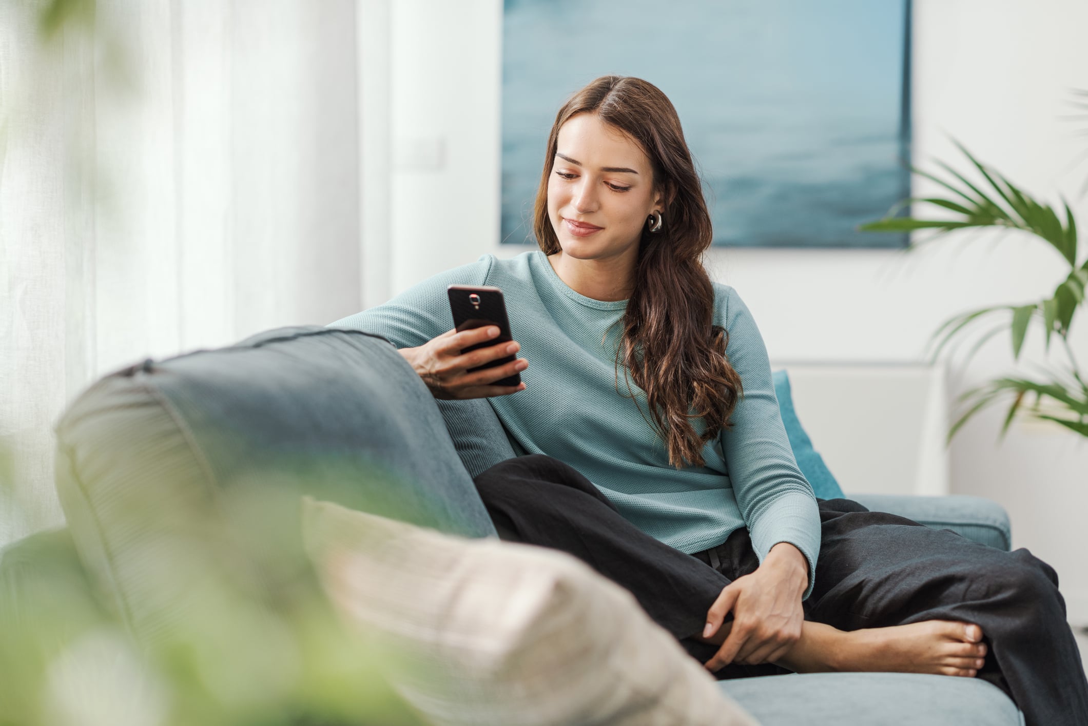 Woman sitting on a couch using her mobile phone