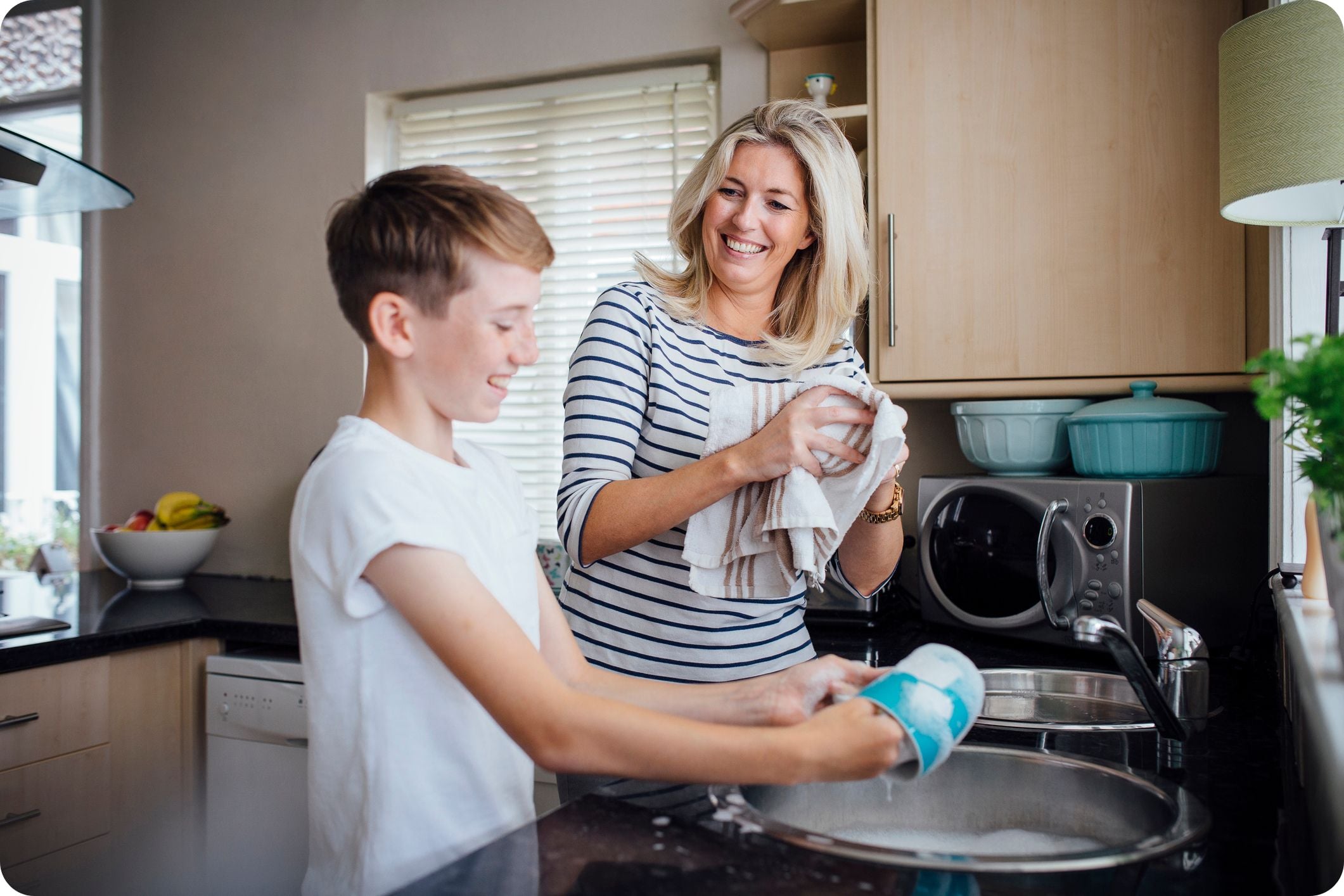 Mother and son washing dishes 