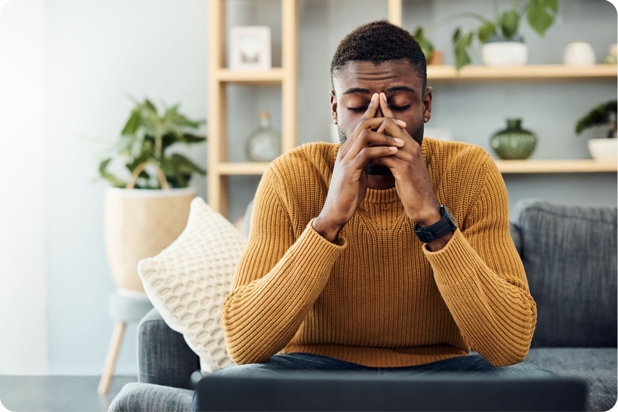 Young man looking stressed while sitting at home