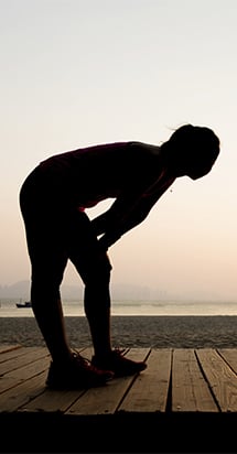 Allianz Care member with a health insurance with pre-existing conditions stretches before jogging.
