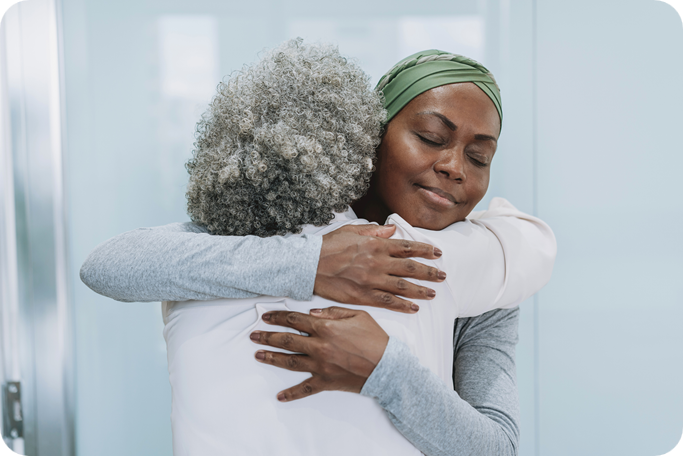 Mother comforts daughter in oncology office hug