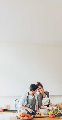 Lovely couple preparing a fresh salad together in the kitchen, reflecting teamwork and motivation in maintaining a healthy diet change.