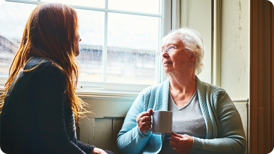 Old woman talking with her young daughter at home 