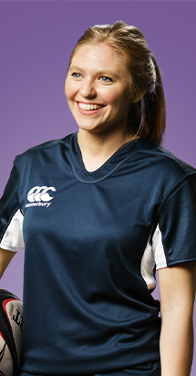 Sport woman confidently smiling while holding her rugby ball