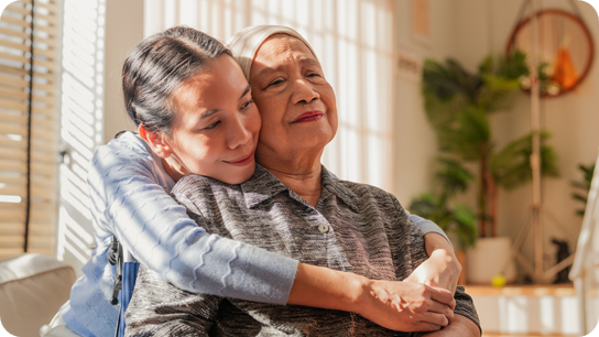 Asian Family, old woman hugging her daughter and cancer with sad people on a sofa in the home living room during recovery.