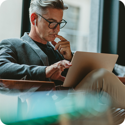 Businessman reading emails in office lobby 
