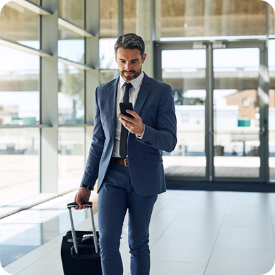 Shot of a mature businessman using a mobile phone while walking through an airport