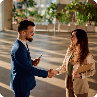 Business partners shaking hands in modern office building lobby