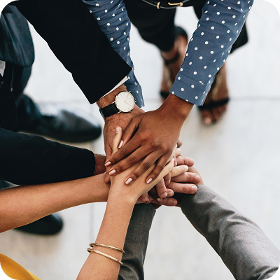 Close up of business people putting their hands together.