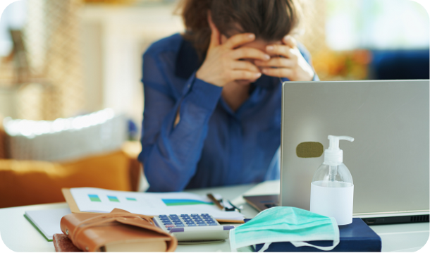 Closeup of a young man in an office holding a briefcase and a surgical mask in his hand