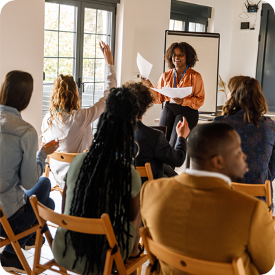 Businesswoman engaging with people in conference room listening to her seminar or presentation