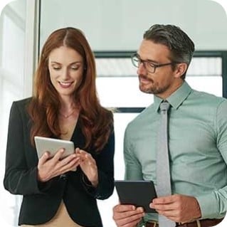 two businesspeople using their tablets in the office