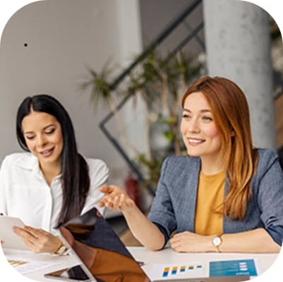 Businesswoman sitting on a meeting at boardroom and discussing analyzes and paperwork with coworkers.