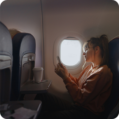Young woman using a phone on board the aircraft