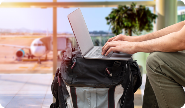 Expat working remotely on a laptop at an airport