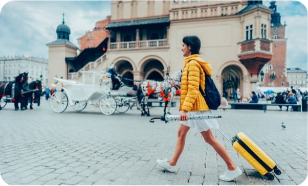 Woman with suitcase and umbrella relocate to live in Krakow