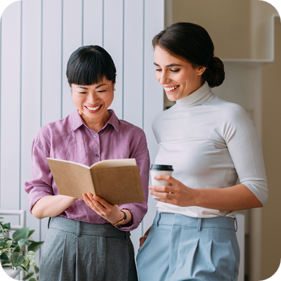 Two happy female co-workers looking at a report