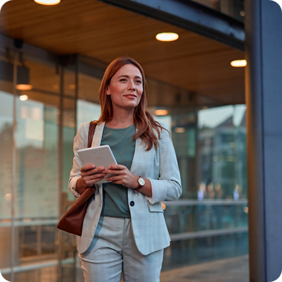 Confident Businesswoman Walking with Tablet in Urban Setting