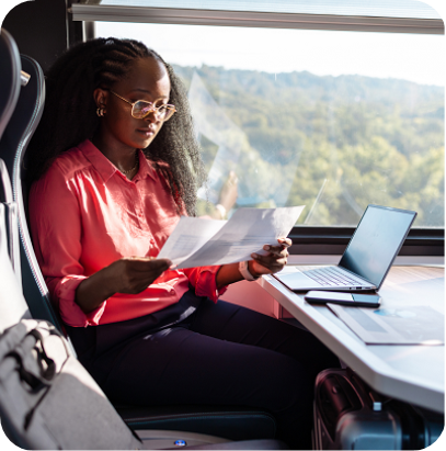 African American businesswoman reviewing documents beside train window