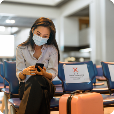 Business woman with mask sitting at the airport