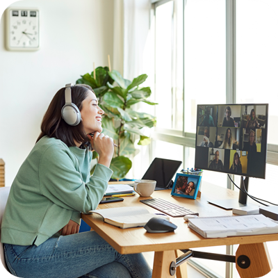 Smiling businesswoman discussing with colleagues through video call.