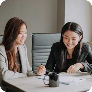 Two Asian Chinese professionals having a business meeting in an office