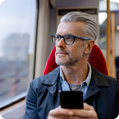 Thoughtful man using his phone while riding on a train