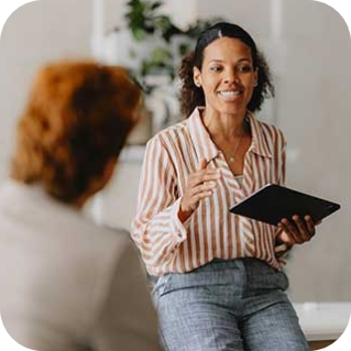 Businesswoman leading a meeting in a bright office, representing how employers can foster teamwork and support employee well-being.