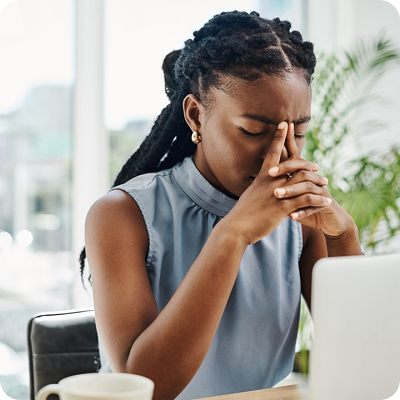 Stressed black businesswoman working on a laptop