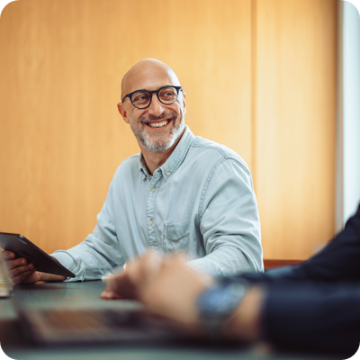 Smiling Businessman in Team Meeting with Colleagues in Office
