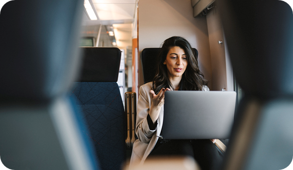 Businesswoman talking on video call through laptop while sitting in train