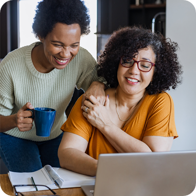 Cheerful gay couple looking at the laptop
