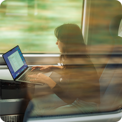 Woman working with laptop while traveling by train