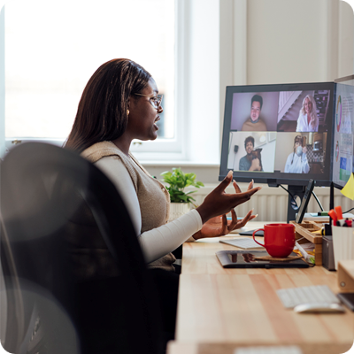 A side view of a manager speaking to her staff who are working from abroad