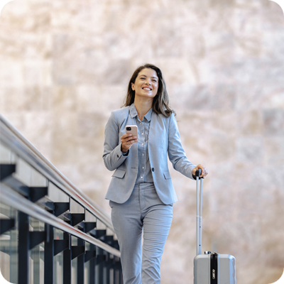 Businesswoman traveling with luggage in modern public station