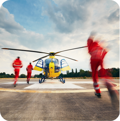 Team of rescuers (paramedic, doctor and pilot) running to the helicopter on the heliport.