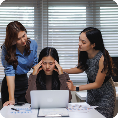 Two colleagues comforting a stressed coworker at her laptop