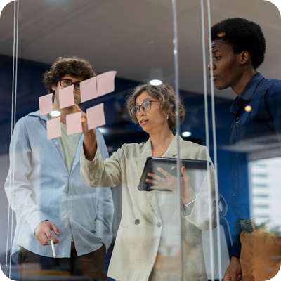A business development team gathers in a modern office meeting room, brainstorming and discussing their business process improvement strategy. 