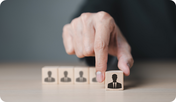 Human resources professional choosing the best candidate for a job, represented by wooden block with icon.
