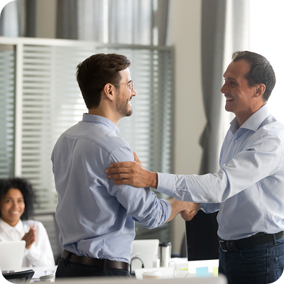 Smiling middle-aged employer and manager shaking hands after the employee received a promotion. 