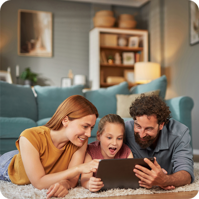 Happy family lying on the floor using digital tablet at home